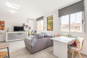 ein Wohnzimmer mit einem Sofa und einem TV in der Unterkunft Apartamento exclusivo y central in Torrevieja