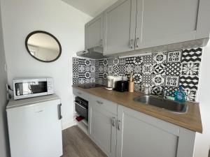 サン・ジル・クロワ・ド・ヴィにあるCap Sudのシンクと電子レンジのある小さなキッチン