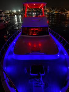 a boat with blue lights on the water at night at ESESYATTURİZM in Istanbul