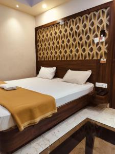 a bedroom with a bed with a wooden headboard at Hotel Park View Near Sea Beach in Puri