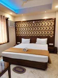 a bedroom with a large bed with a wooden headboard at Hotel Park View Near Sea Beach in Puri