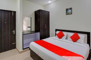um quarto com uma cama grande e almofadas vermelhas em Super OYO Flagship A R V Palace em Lucknow