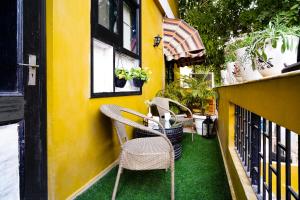 eine Terrasse mit 2 Stühlen und einem Tisch auf dem Balkon in der Unterkunft Cozy Inn in Gurgaon