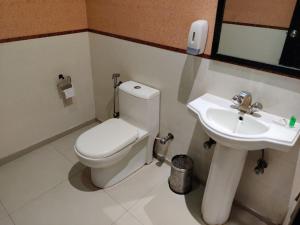 a bathroom with a toilet and a sink at Hotel Samrat Heavens Meerut in Meerut