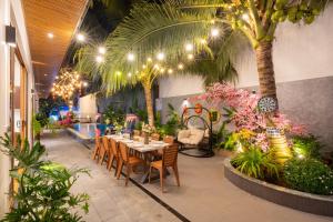 un restaurante con mesa, sillas y palmeras en Villa Không Lầu 5 Phòng Ngủ - Phan Chu Trinh, en Vung Tau 19 fotos más