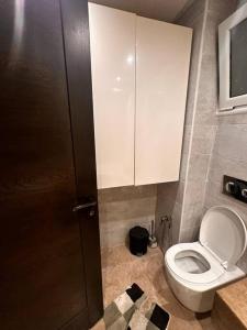 a bathroom with a white toilet and a cabinet at luxueux S2 avec piscine in Sukrah