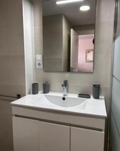 Un baño con un lavabo blanco y un espejo. en Balcón Tridente, en Alicante