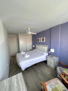 1 dormitorio con 2 camas y pared azul en Balcón Tridente, en Alicante