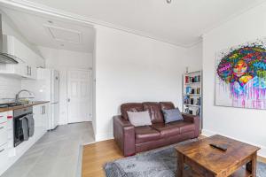 a living room with a couch and a table at Bright West Ealing Abode in Hanwell
