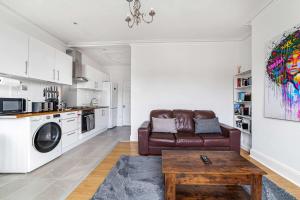 a living room with a couch and a table at Bright West Ealing Abode in Hanwell