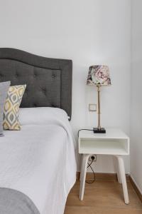 a white bed with a white nightstand next to a bed with a white bed at Hotel Madrid in Torrevieja