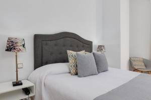 a bedroom with a large white bed with pillows at Hotel Madrid in Torrevieja