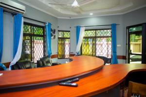 einen Konferenzraum mit einem großen Holztisch und Stühlen in der Unterkunft Magdon Executive Lodge in Daressalam