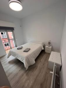 a white bedroom with a bed and a table at Casa Unifamiliar Completa Camas Sevilla in Camas