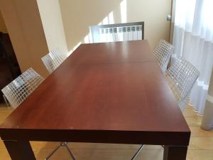 una gran mesa de madera en una habitación con sillas en Pis de bon disseny i sostenible., en Manresa
