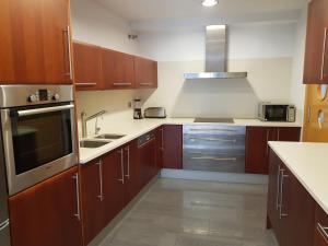 una cocina con armarios de madera y electrodomésticos de acero inoxidable en Pis de bon disseny i sostenible., en Manresa 17 fotos más