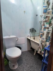 a bathroom with a toilet and a sink and a shower curtain at Уютная квартира возле ТЦ Вавилон, Ж/м Солнечный, Малиновского 12, 1-к in Dnipro
