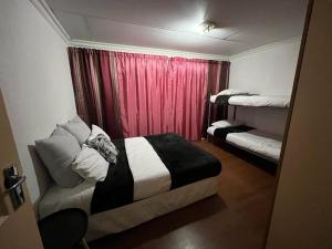 a bedroom with two beds and a red curtain at Kharimbi Camp House in Brakpan