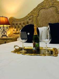 a tray with a bottle and two glasses on a bed at Afrite Rooms Goodwood in Cape Town