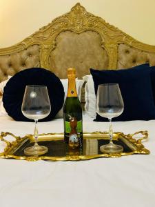 a bottle of wine and two glasses on a tray on a bed at Afrite Rooms Goodwood in Cape Town