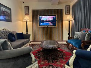 un soggiorno con divani e TV a parete di Afrite Rooms Goodwood a Città del Capo
