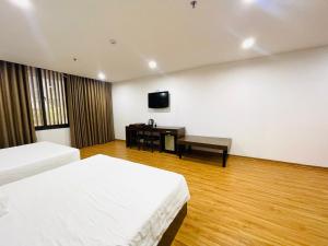 a hotel room with two beds and a television at SILANA HOTEL & APARTMENT in Da Nang
