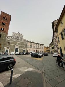 una calle de la ciudad con coches estacionados frente a los edificios en San Pietro Tuscany Suites, en Lucca