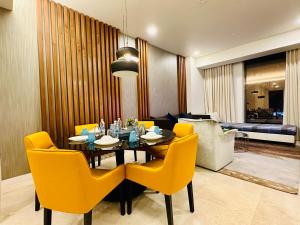 une salle à manger avec une table et des chaises jaunes dans l'établissement Tropicana The Residence By Klcc, à Kuala Lumpur