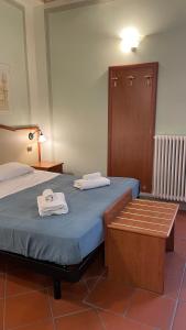 1 dormitorio con 1 cama con toallas en San Pietro Tuscany Suites, en Lucca