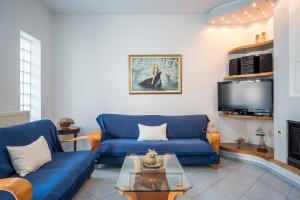 sala de estar con 2 sofás azules y TV en apartment, en Néa Alikarnassós