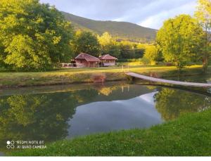 a bridge over a pond with a house in the background at Vodenica Lug in Strmosten +82 photos