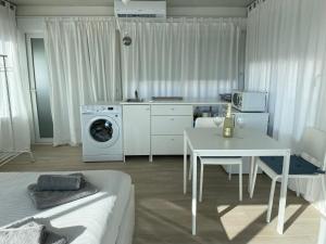 een keuken en een woonkamer met een wasmachine en een tafel bij Ático Cádiz 360 in Cádiz