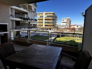 balcón con mesa y sillas y vistas a un edificio en Ampia Piscina Condominiale [Nuovo Monolocale] en Mostacciano 