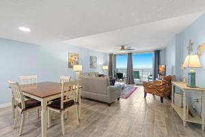 a dining room and living room with a table and chairs at Coronado Towers 703 in New Smyrna Beach
