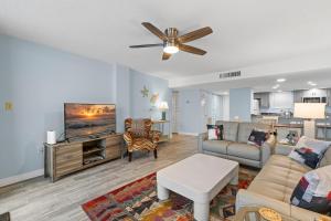 a living room with a couch and a flat screen tv at Coronado Towers 703 in New Smyrna Beach