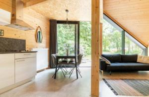 cocina y sala de estar con sofá y mesa en Vakantiepark de Eikenhof, en Paasloo