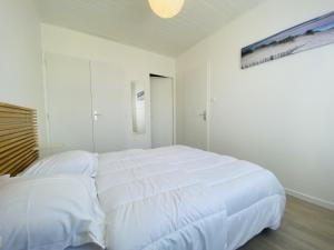 una camera bianca con due letti e una finestra di Maison renovee avec gout 700m de la plage a Saint-Gilles-Croix-de-Vie