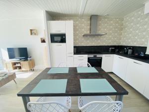 una cucina con tavolo e sedie in una stanza di Maison renovee avec gout 700m de la plage a Saint-Gilles-Croix-de-Vie