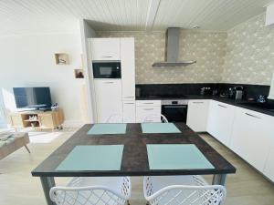 Una cocina con una mesa y sillas en una habitación. en L'Aigue Marine, en Saint Gilles Croix de vie