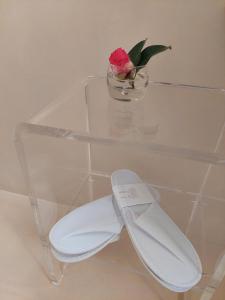 a glass shelf with a pink flower in a vase at Dolceresio Lugano Lake B&B in Brusino Arsizio +74 photos