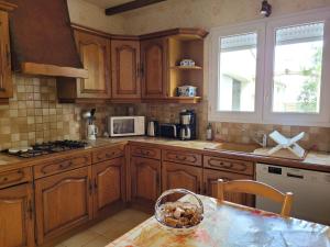 a kitchen with wooden cabinets and a table with a bowl at La Garenne in Saint-Jean-de-Monts