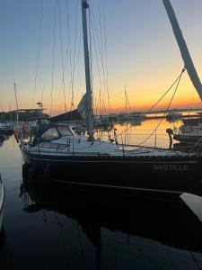 Łódź zakotwiczona jest w przystani o zachodzie słońca. w obiekcie Sail & Fun Team Szczecin - Rejsy Jachtem - Jacht Czartery w Szczecinie