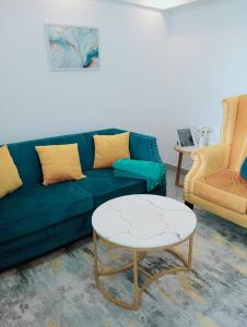 a living room with a blue couch and a table at Wanderstay kenya in Nairobi