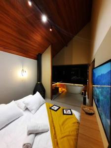 a bedroom with a large bed and a bath tub at Chalé Mury in Nova Friburgo