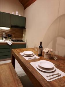a kitchen with a table with plates and a bottle of wine at Chalé Mury in Nova Friburgo