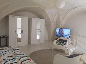 ein Schlafzimmer mit einem Bett und einem TV in einem Zimmer in der Unterkunft loft corte pisanelli in Casarano