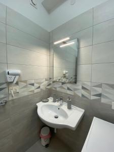 een witte badkamer met een wastafel en een spiegel bij Seaway Accommodation " Private Parking " in Tropea