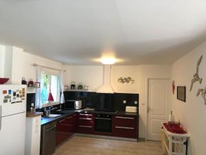eine Küche mit braunen Schränken und einem weißen Kühlschrank in der Unterkunft Maison accueillante en Normandie in Montivilliers