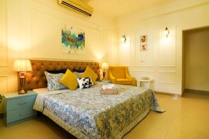 1 dormitorio con 1 cama y 1 silla amarilla en Cozy Inn en Gurgaon