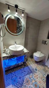 een badkamer met een wastafel, een toilet en een spiegel bij Modern Apartment Kallithea 2 in Kallithea